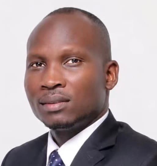 Professional headshot of a Black man with a shaved head wearing a suit and tie.